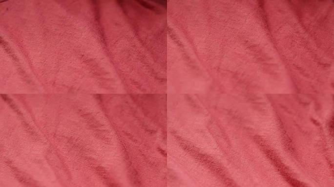 纺织品商店中一种光滑的红色混合涤棉织物的特写镜头。机架聚焦