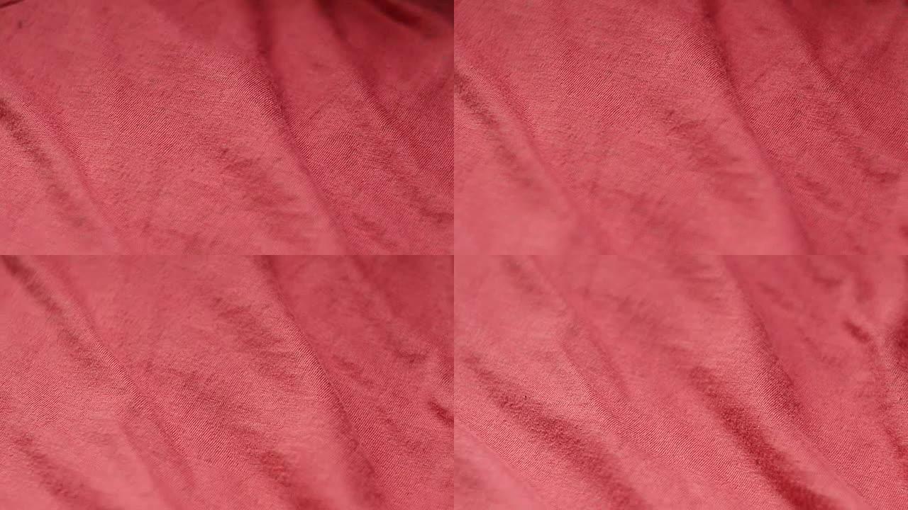 纺织品商店中一种光滑的红色混合涤棉织物的特写镜头。机架聚焦