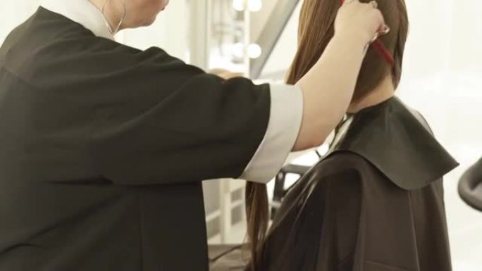 美发沙龙女性理发时理发师梳理湿发。在美容院近距离理发的美发师