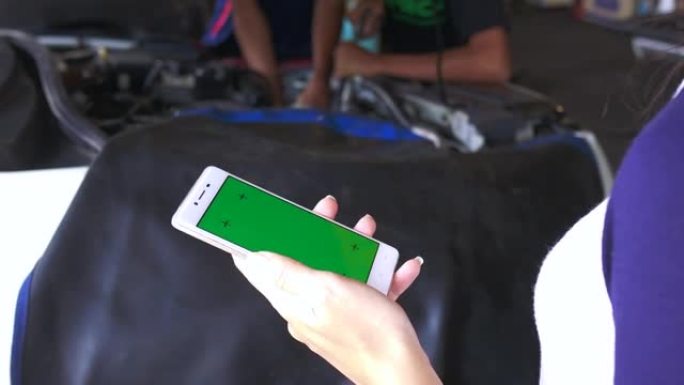 女人在车库里使用绿屏手机