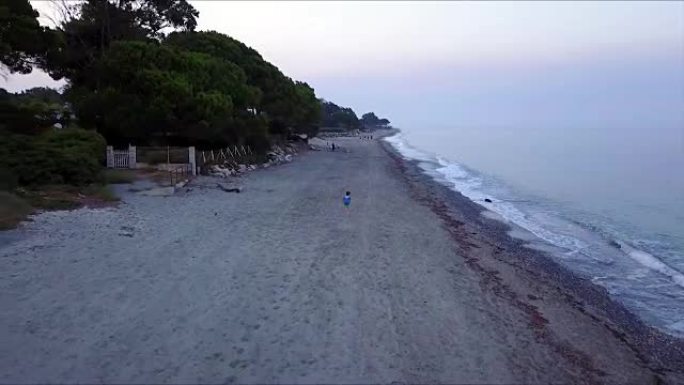 一个男孩在海滩上快速奔跑，鸟瞰图
