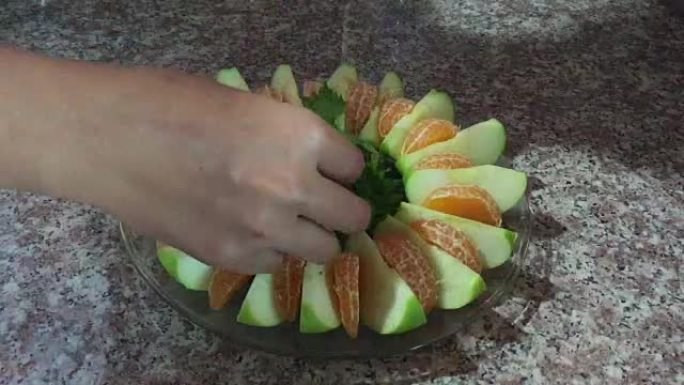 将青苹果，芹菜和橙色水果放在盘子上