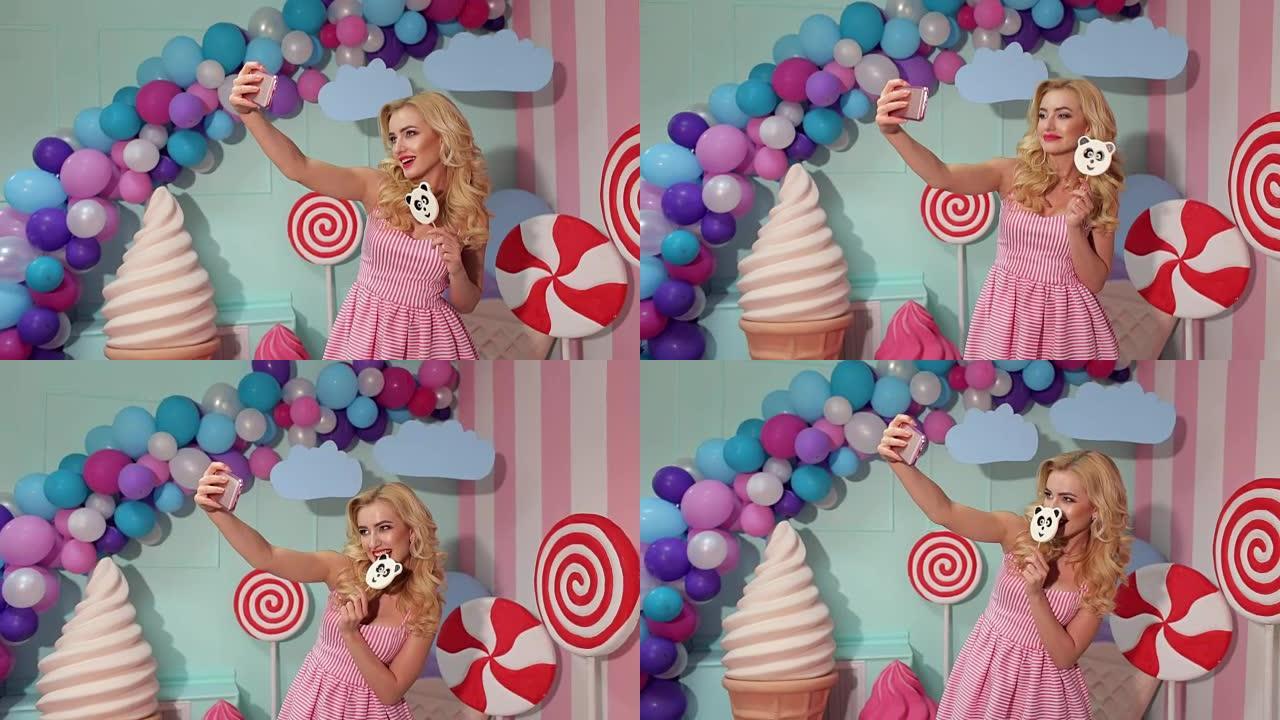 穿着粉色连衣裙的女孩和大棒棒糖自拍。