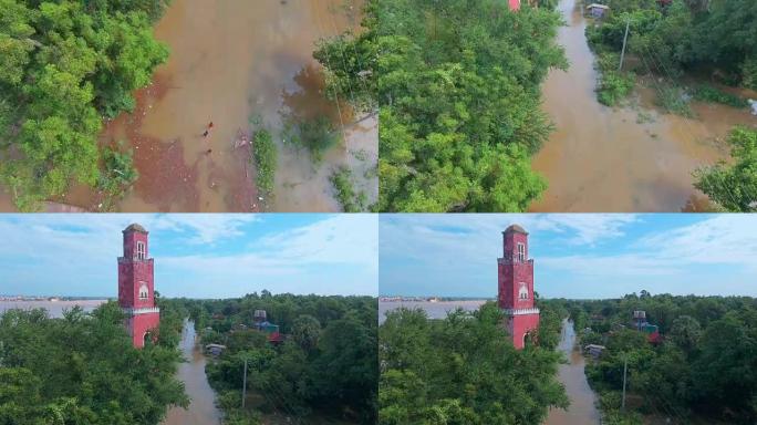 空中无人机射击显示人们在沿河的旧望塔的道路村庄中移动