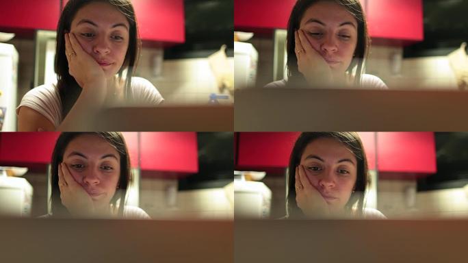 在电脑屏幕前浏览互联网的疲惫的30岁女人的偷拍4k剪辑