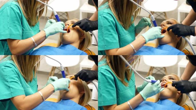 一名女牙医正在为一名年轻女子清除牙菌斑