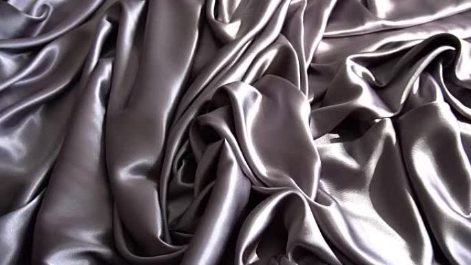 背景纹理柔软的银色织物纺织材料反向移动。