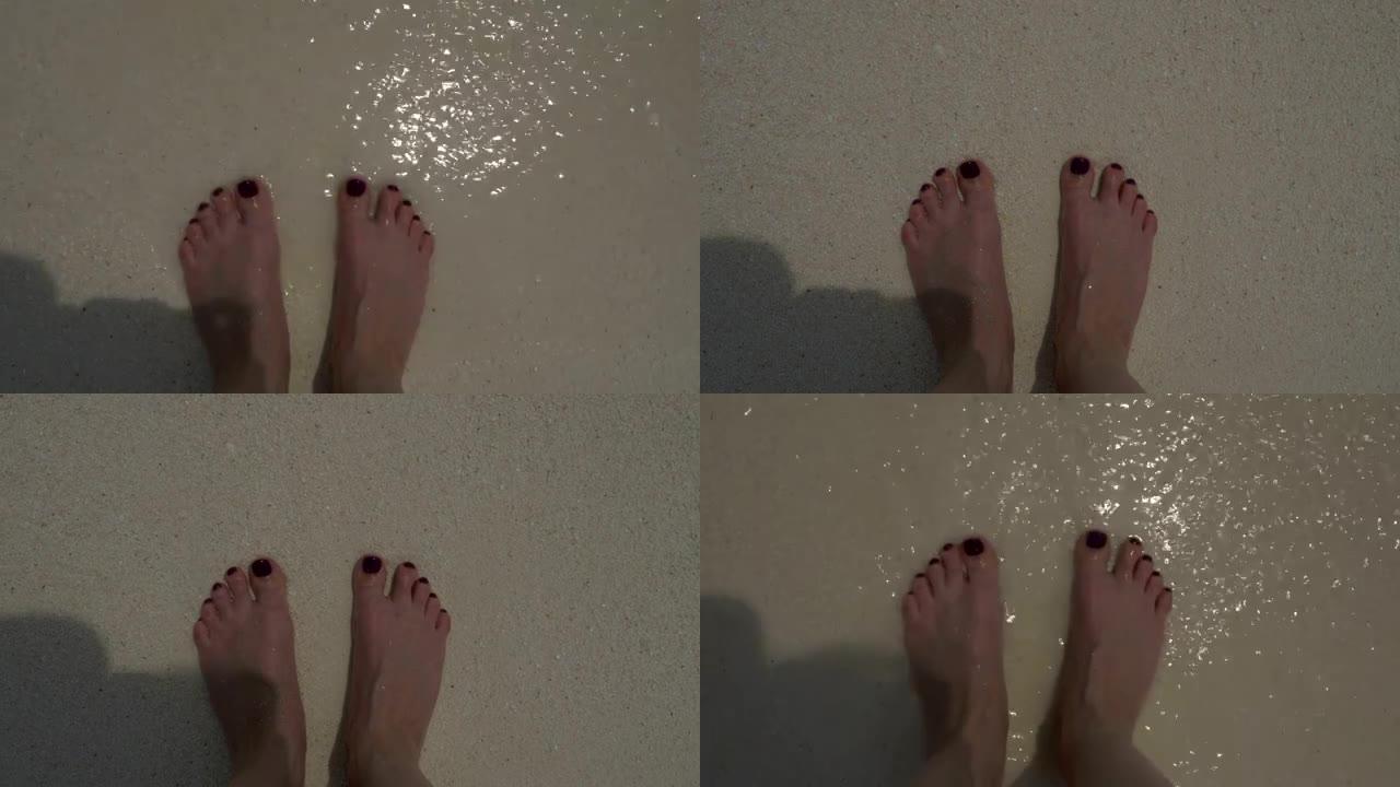 沙滩上的海浪，海沫和妇女的赤脚。