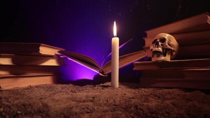 巫师的桌子。蜡烛灯点亮的桌子。人类头骨，沙子表面的旧书。万圣节静物美背景，深色雾状背景上有不同的元素