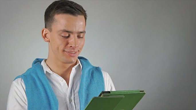 年轻有魅力的学生。绿色平板电脑。