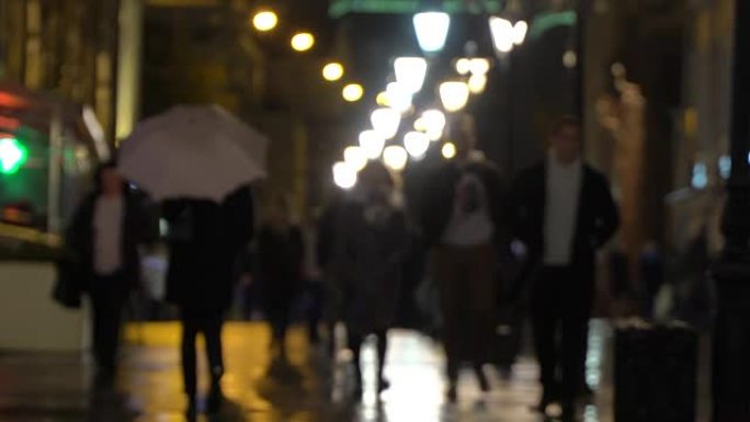 夜城雨。下雨的夜晚在城市街道上，有路灯，雨水中有闪亮的沥青。无法辨认的行人，年轻人，带白伞的女孩。现