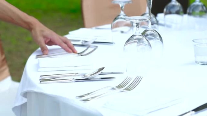 餐厅工作人员为晚宴或婚宴设置室外餐桌。