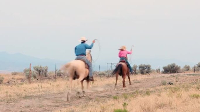 牛仔和女牛仔在土路上骑马