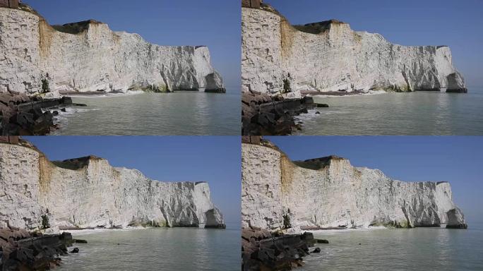 白色粉笔悬崖西福德东萨塞克斯郡英国附近的七姐妹，海浪拍打悬崖和蓝色的大海和天空