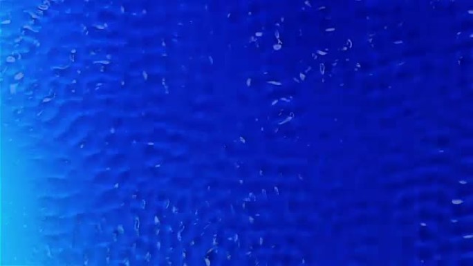 水在振动的作用下产生图形纹理。蓝色背景。慢动作