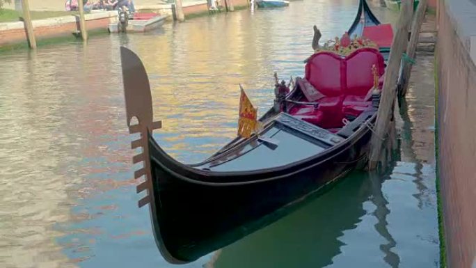 运河一侧漂浮的黑色威尼斯吊船