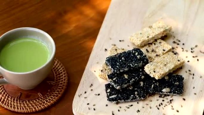绿茶随时可以喝，与谷物，烤白芝麻和芝麻放在木盘子上，为需要保健的人提供食物。