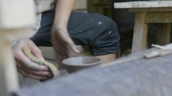 工艺陶瓷的小企业; 靠近陶工的手，用投掷陶瓷工艺在圆轮上制作一个杯子-股票视频