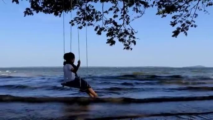asian little girl on wooden swing