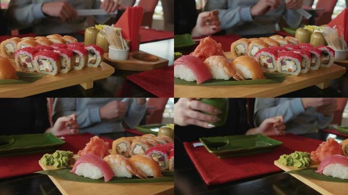 年轻夫妇用筷子从日本餐馆的盘子里拿寿司。