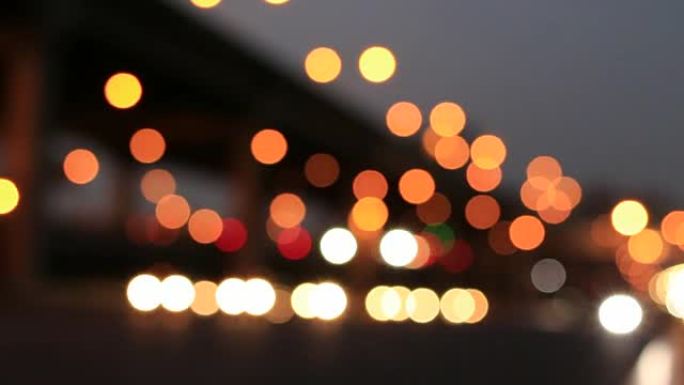下雨后午夜街道上的灯光，光线背景的抽象圆形粒子，运动镜头模糊城市背景和夜晚的路灯