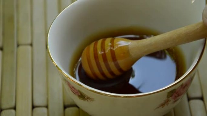 从杯子里手工采摘木制蜂蜜勺