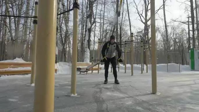 年轻人在户外冬季运动场用健身带训练