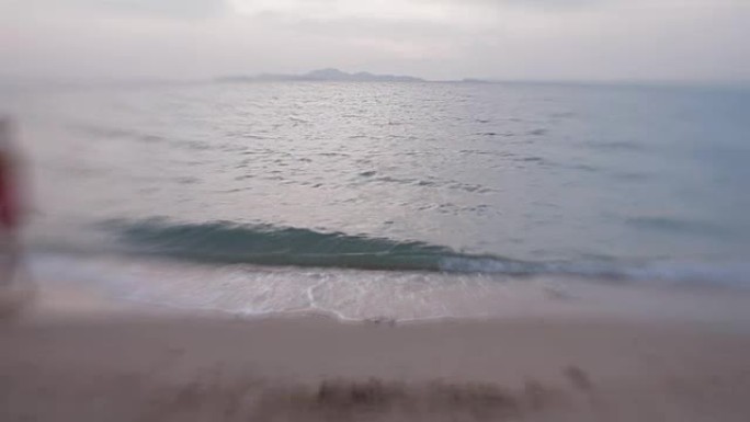 海上冲浪。海浪抹去了女人在沙滩上的脚印。泰国芭堤雅。用镜头拍摄婴儿甜美35毫米