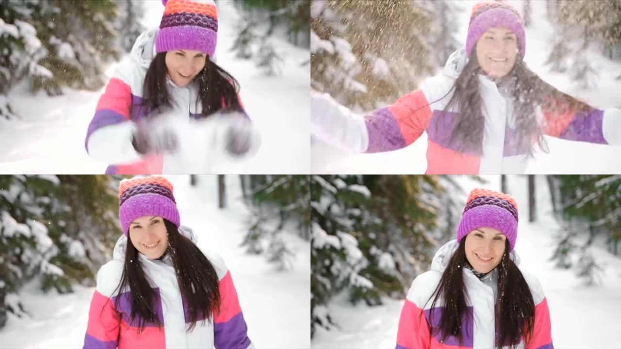年轻女子享受阳光明媚的冬日，在户外扔雪。慢动作