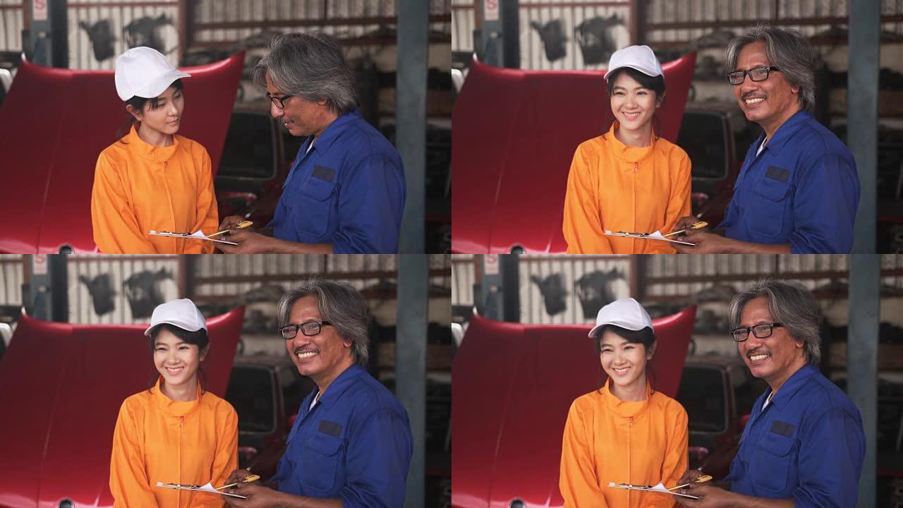 高级机械师向亚洲年轻女修车师建议并微笑