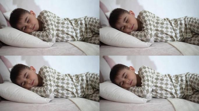 一个穿着睡衣的小男孩睡在床上