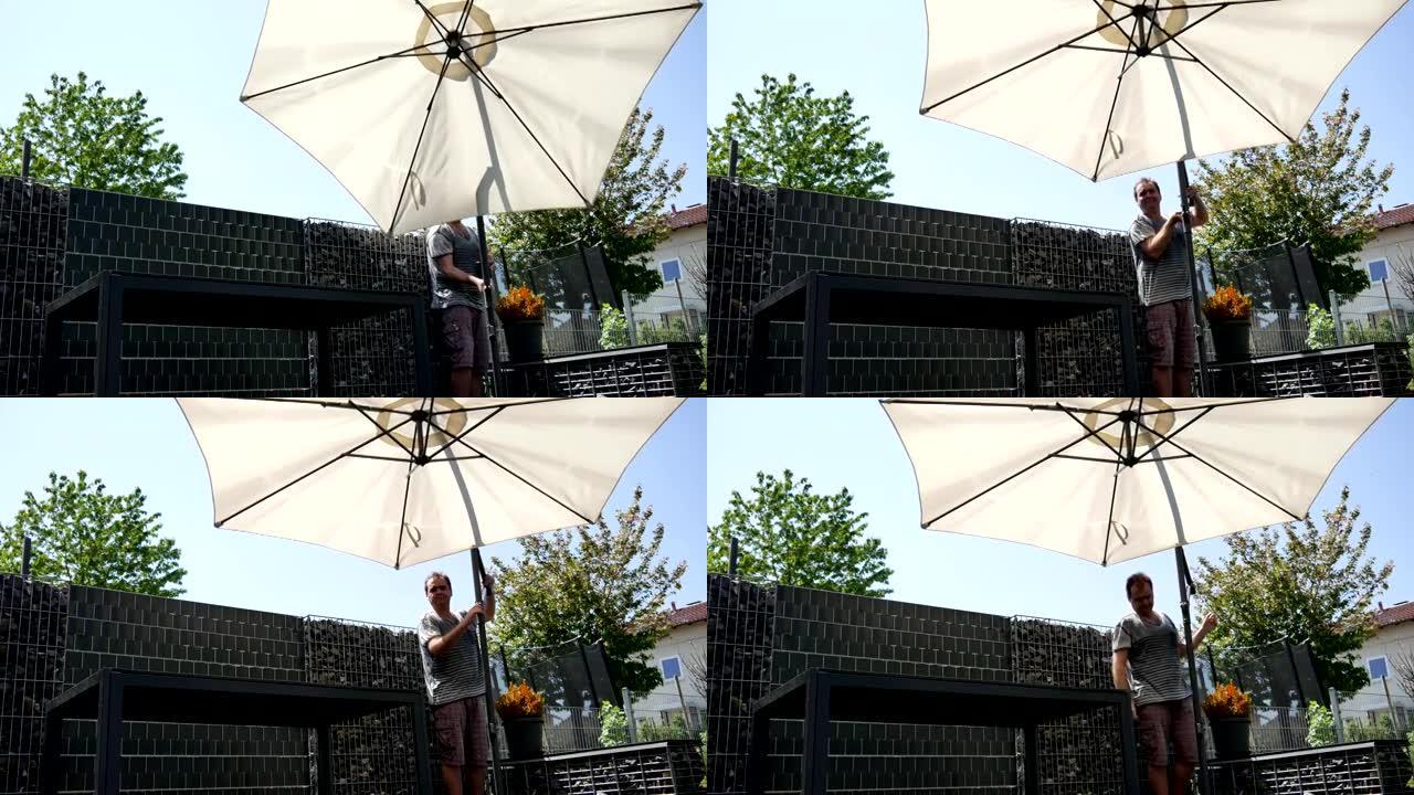 一名男子在露台上从阳光下打开雨伞