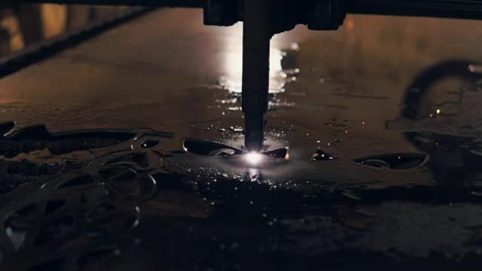 工业激光切割机是在钢板上雕刻图案，特写