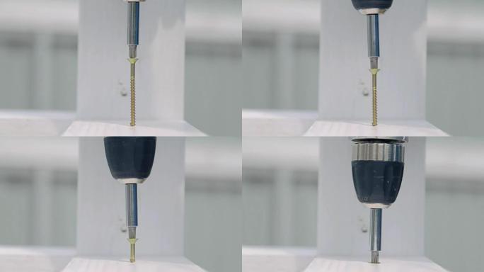 建筑工人使用电动螺丝刀通过金属螺钉固定木板。特写
