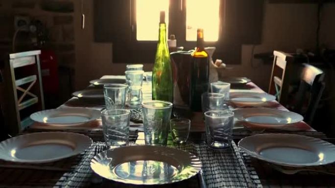 乡村餐桌供应晚餐，配有葡萄酒和回收玻璃