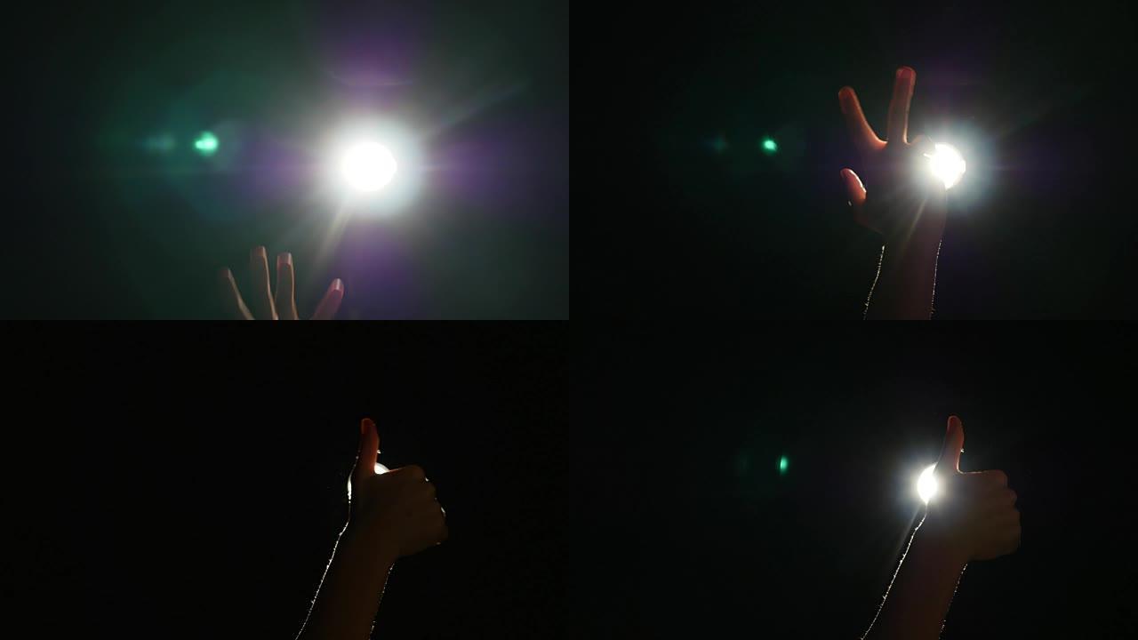 人类男性手的深色轮廓，在聚光灯下抬起手指或背光光，在黑色背景上带有手势，带有戏剧性的投影仪，光线或光