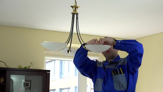 经验丰富的电工在客户家里更换灯泡