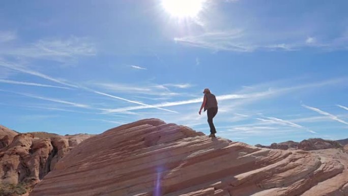 运动徒步旅行女子爬上红色岩石背景天空慢动作4K