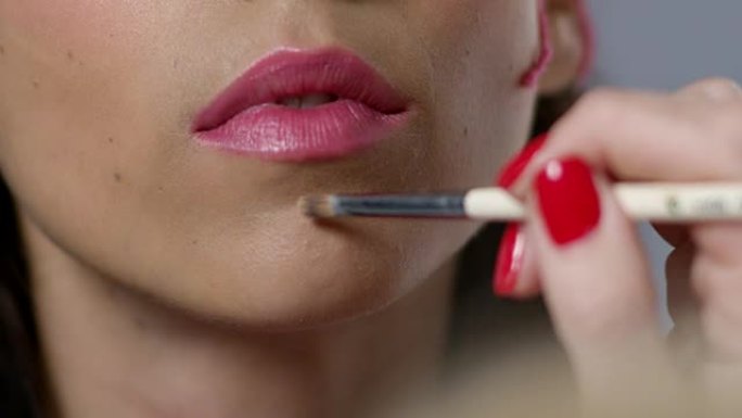 化妆师流氓模特嘴唇的超级特写后台。时尚视频。