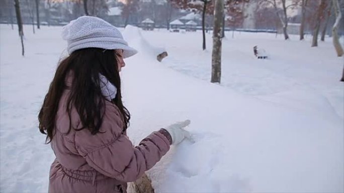 十几岁的女孩在雪地里画心形