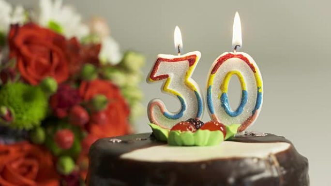 多莉: 插花和30号燃烧蜡烛的生日蛋糕