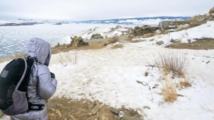 女人在贝加尔湖冰上的旅行。关闭独特的佛教佛塔布尔汉纪念碑象征神秘的历史仪式岛Ogoi景观山萨满崇拜。