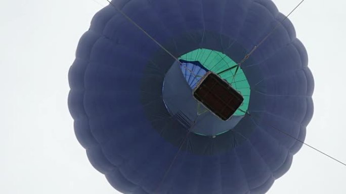 热气球。燃烧器将火焰引导到天空中背景氦飞艇上的信封中