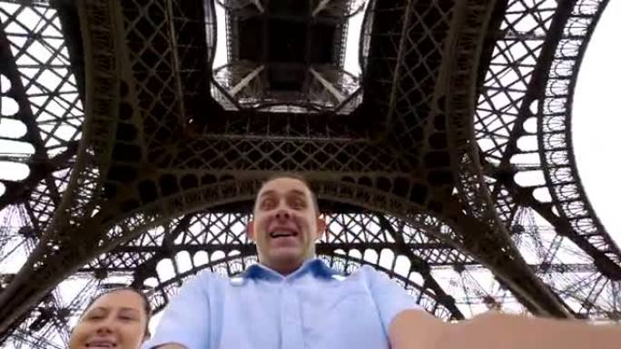 快乐的男人和女人在4k慢动作的巴黎埃菲尔铁塔下旋转和玩乐