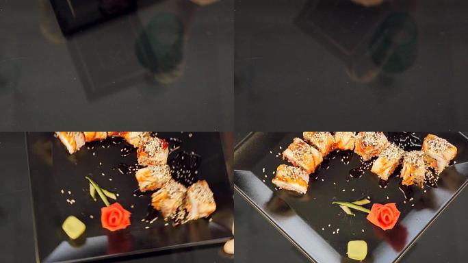 黑色盘子上的寿司装饰着生姜玫瑰