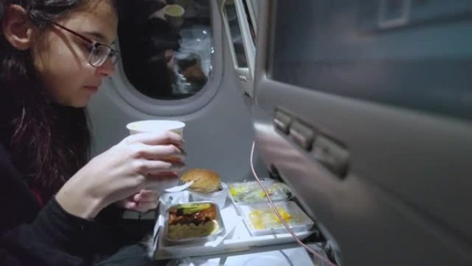 十几岁的女孩在国际航班上吃饭