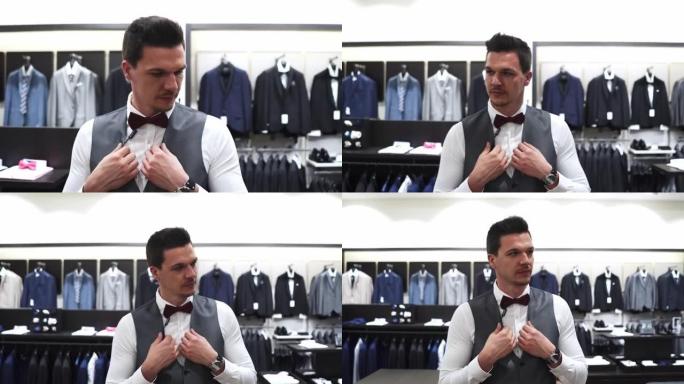 他正在一家时尚的优雅商店为婚礼选择合适的西装
