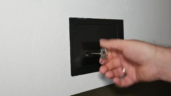 男子在酒店打开金库或保险箱，手动键入安全密码并解锁门或保险箱。