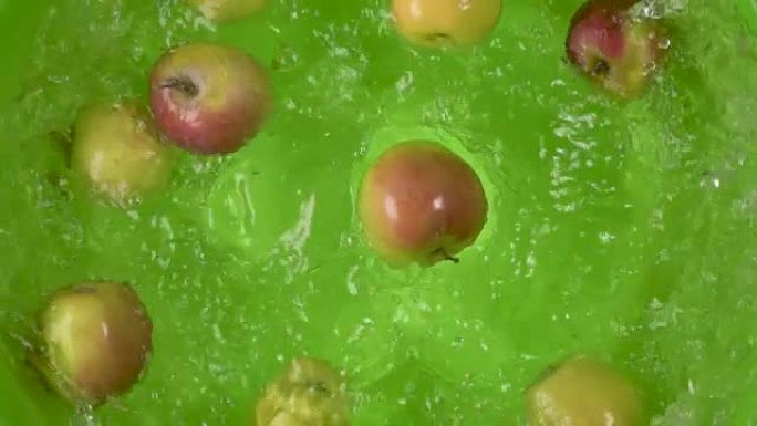慢动作苹果掉入一个容器的水顶视图