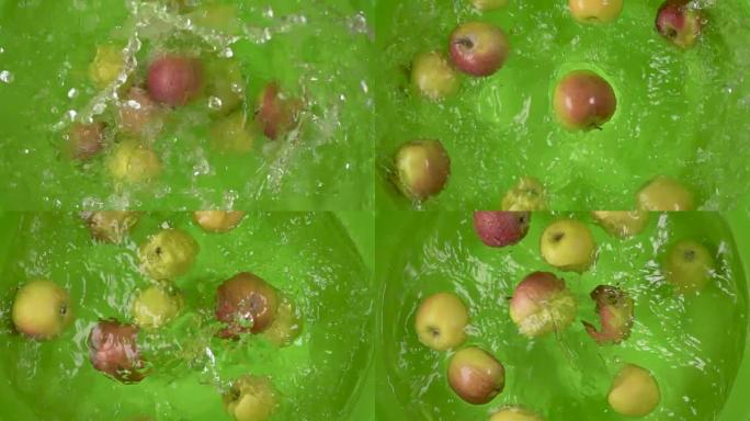 慢动作苹果掉入一个容器的水顶视图
